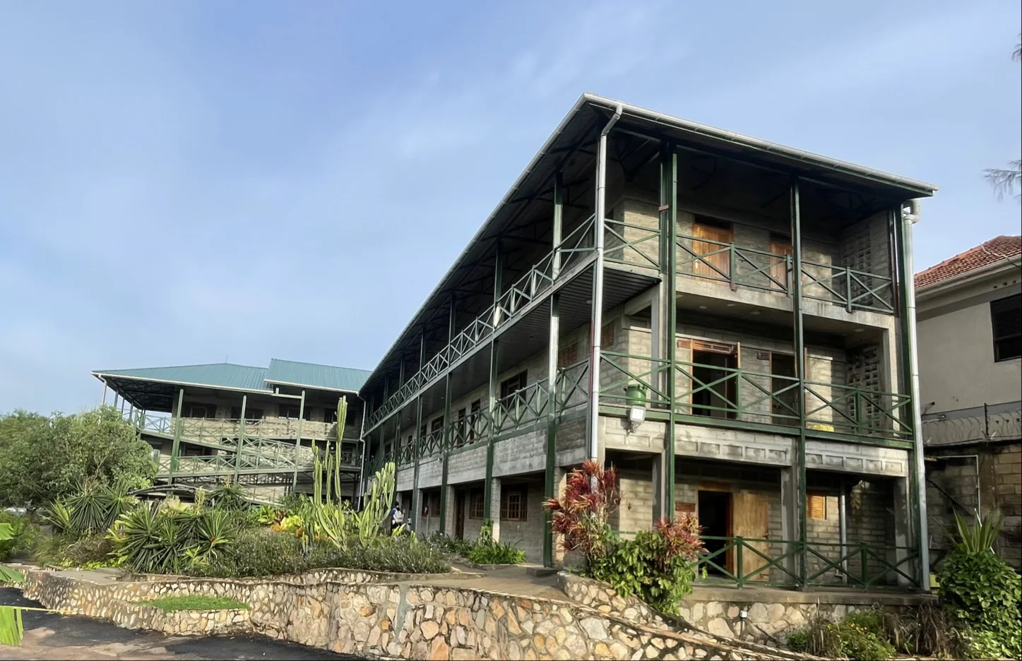 Multi-storey modular building with green steel frame and landscaped grounds