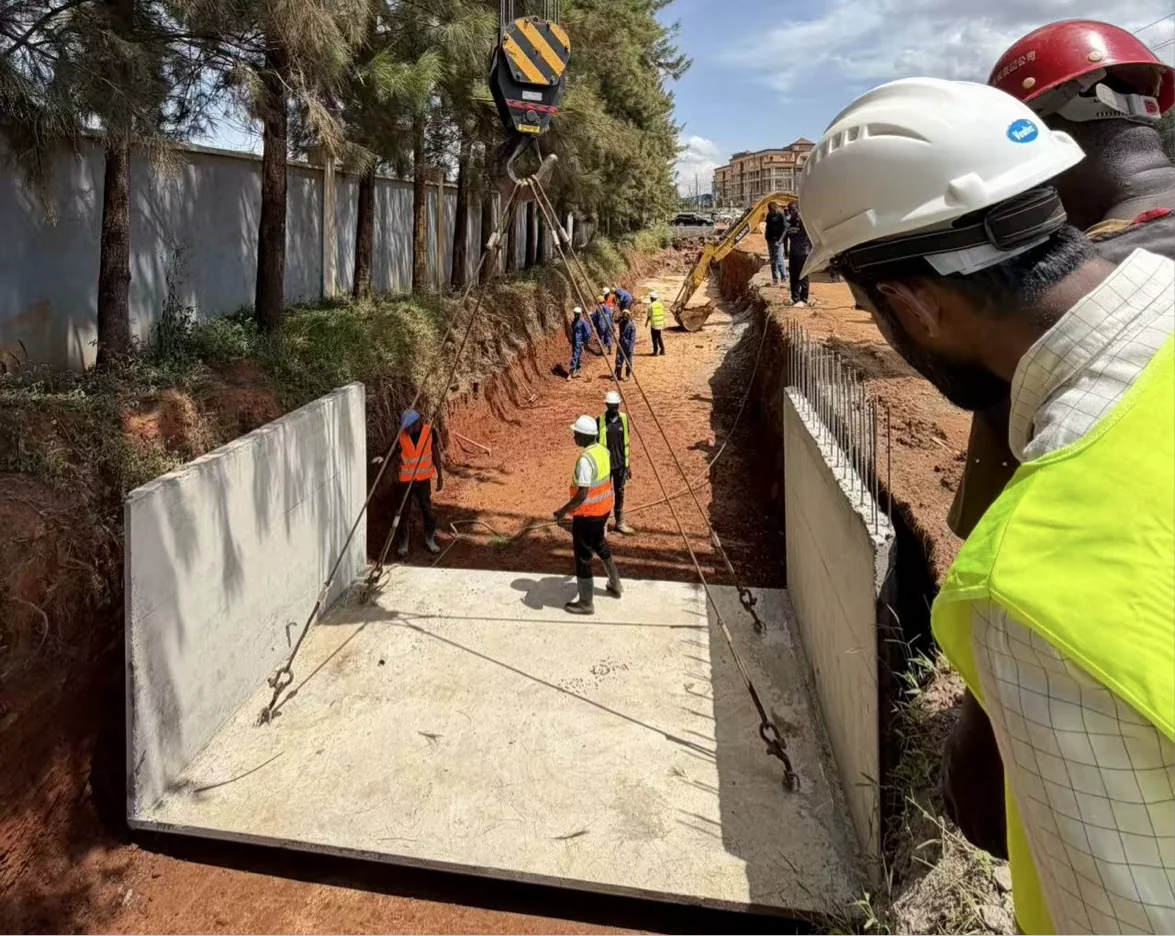 Site worker beside a concrete drainage channel under construction