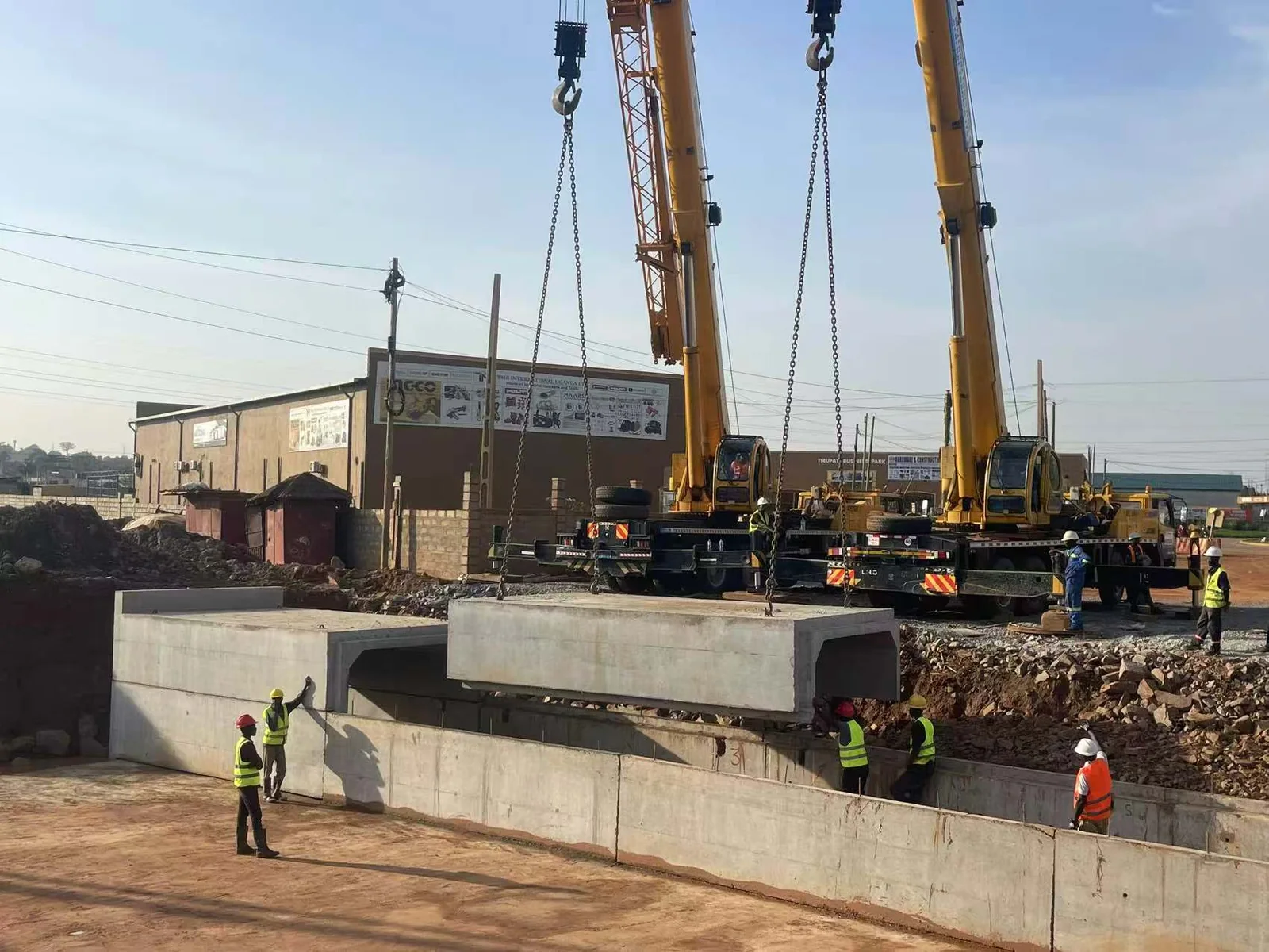 Cranes and site team installing a precast concrete culvert